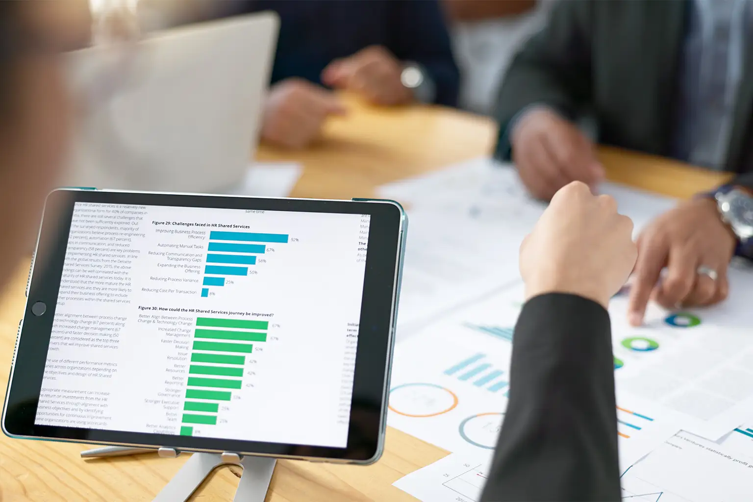 People review statistics on a tablet screen.